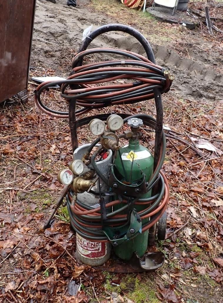 A portable oxy-acetylene welding cart with two gas tanks and gauges.