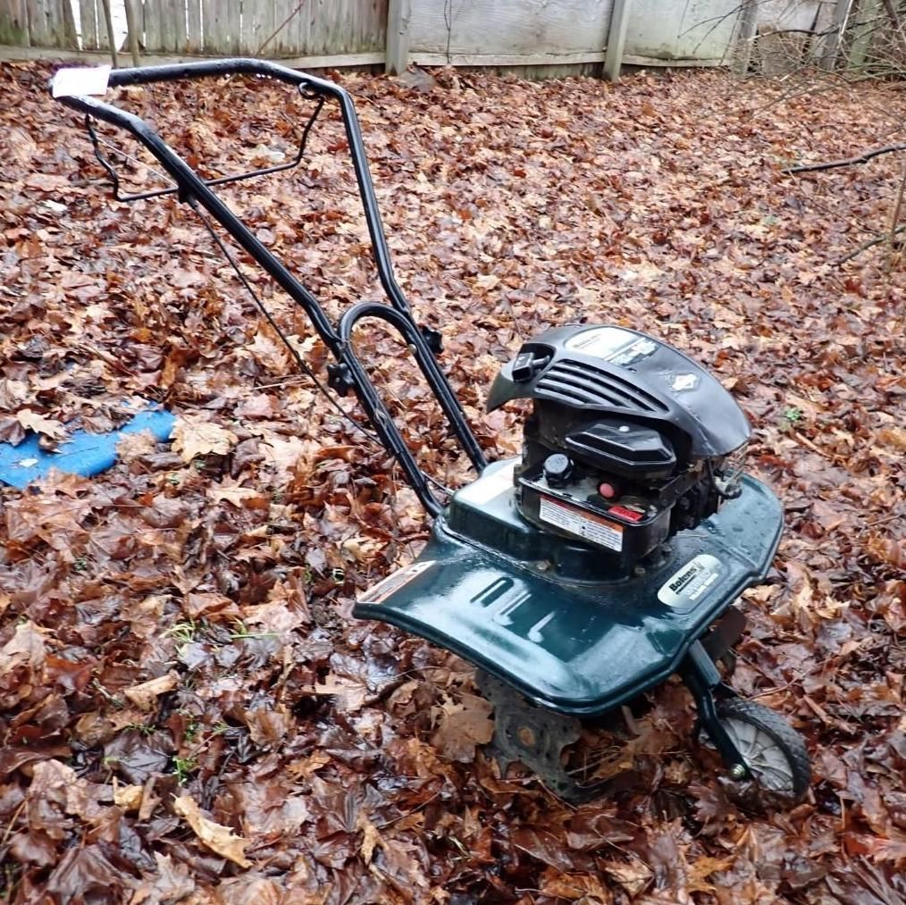 A green gas-powered garden tiller.