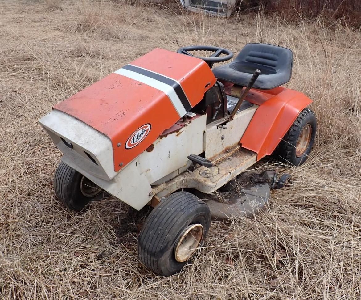 A vintage orange and white lawn tractor with a black racing stripe.