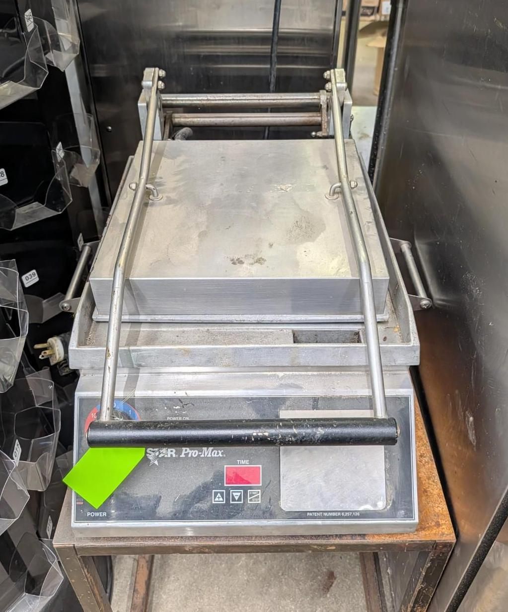 Commercial food slicer on a wooden table in a kitchen setting