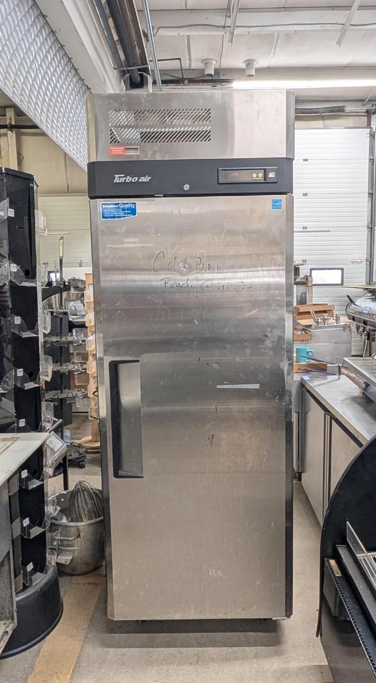 Stainless steel commercial refrigerator in an industrial kitchen or storage area