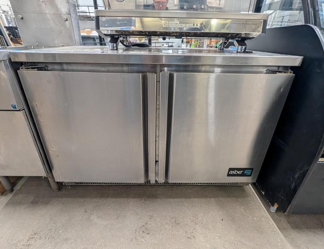 Stainless steel two-door undercounter refrigerator in a commercial kitchen or restaurant setting