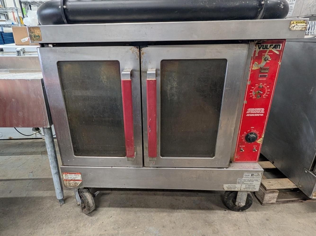 Stainless steel commercial kitchen oven with glass doors and red control panel on casters