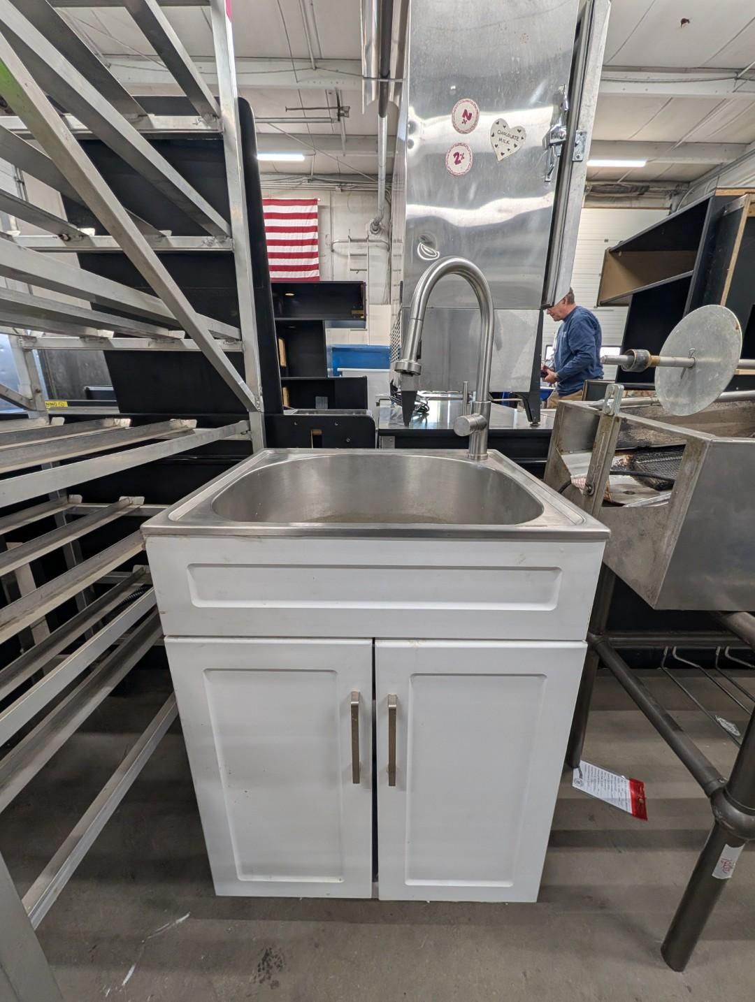 Stainless steel sink cabinet in a warehouse aisle
