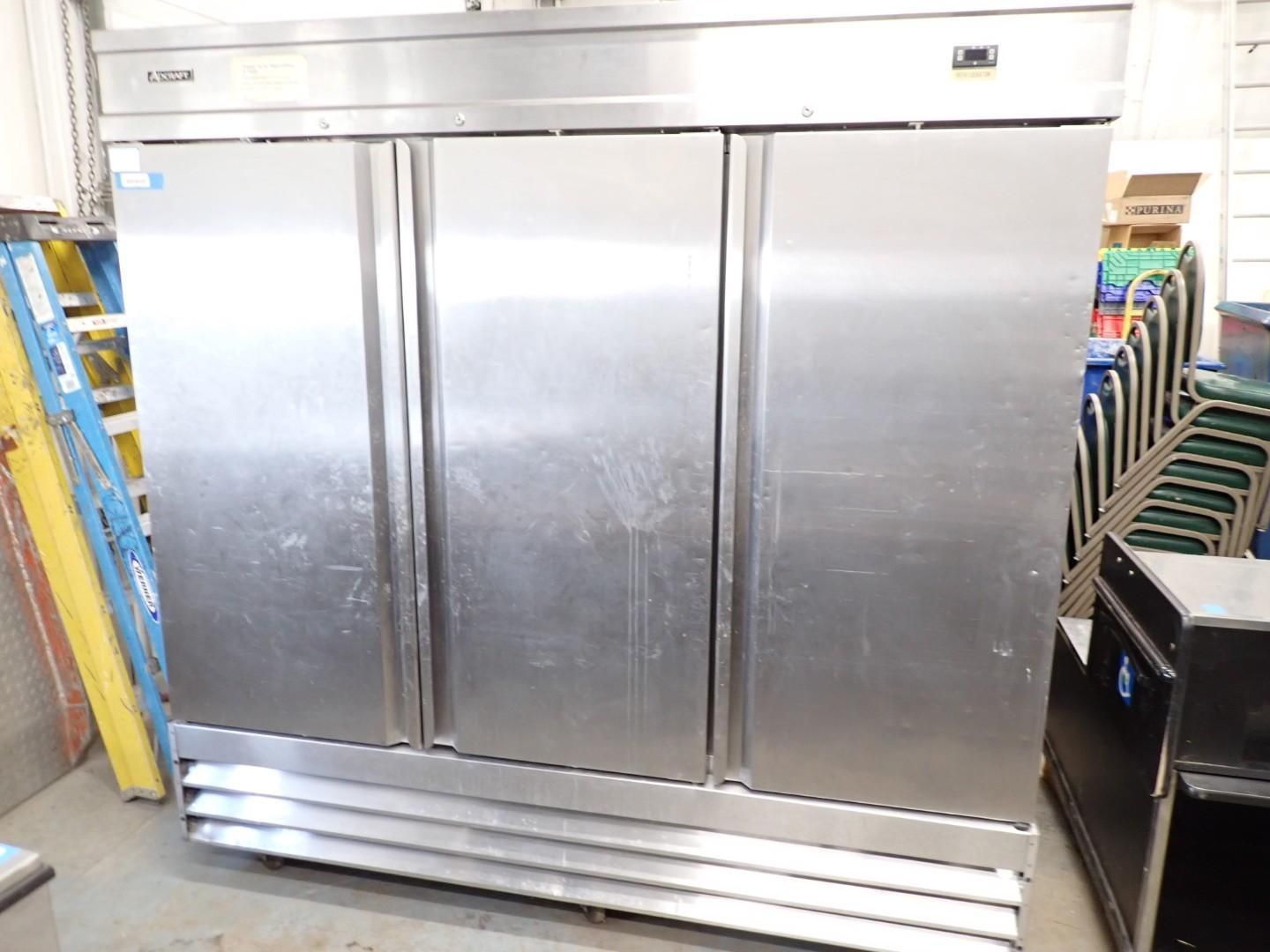 Three-door stainless steel commercial refrigerator in a store aisle