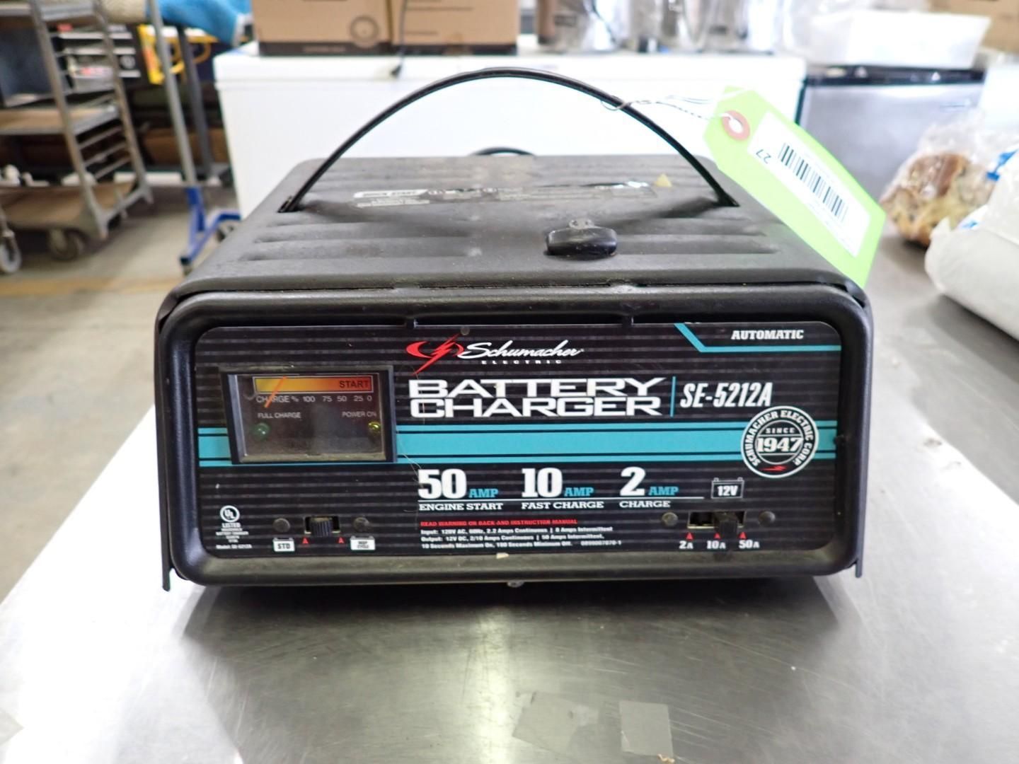 Vintage black radio on a table with teal and white front panel display, in a workshop or store setting