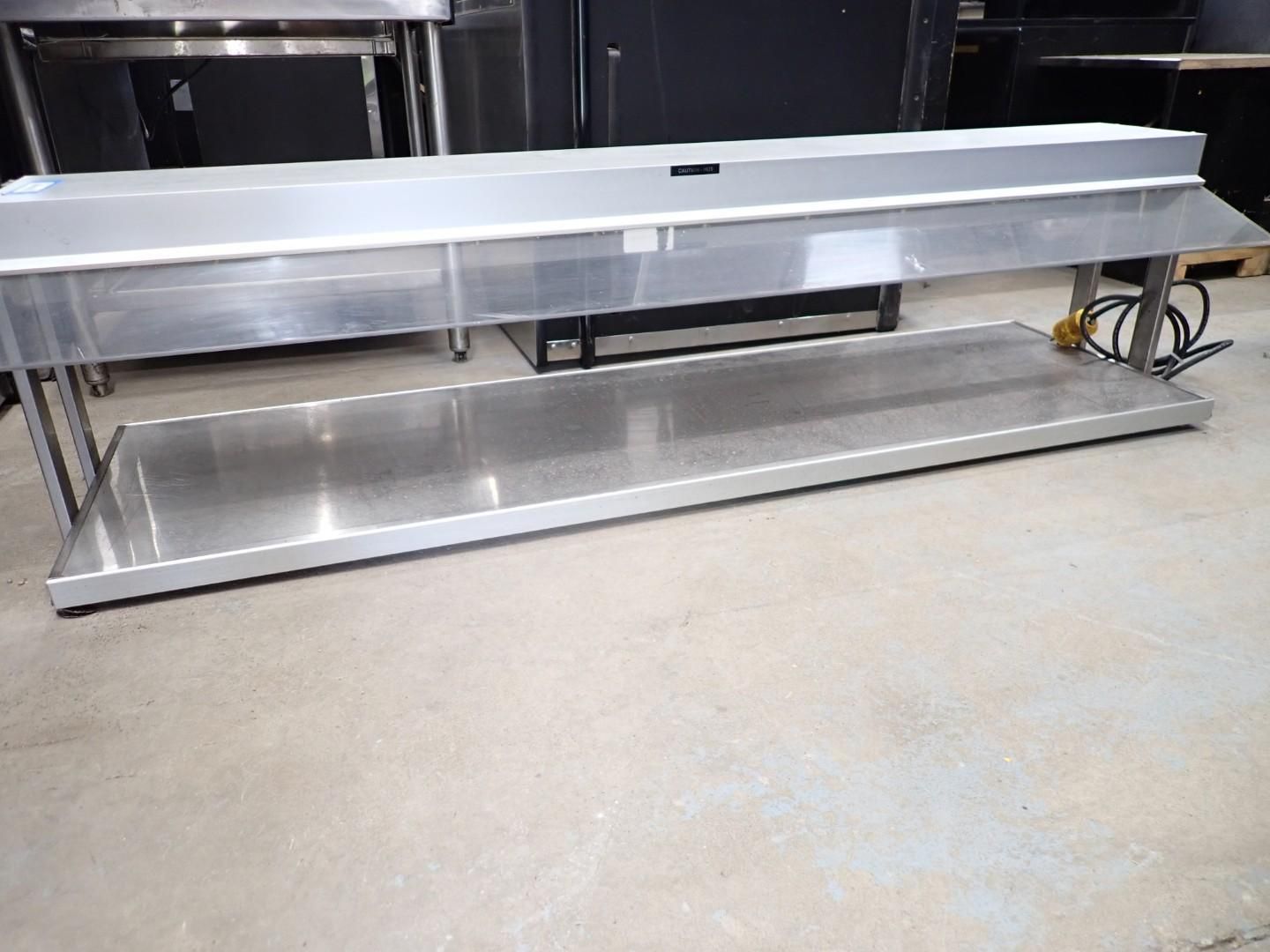 Stainless steel commercial prep table on a concrete floor in an industrial kitchen