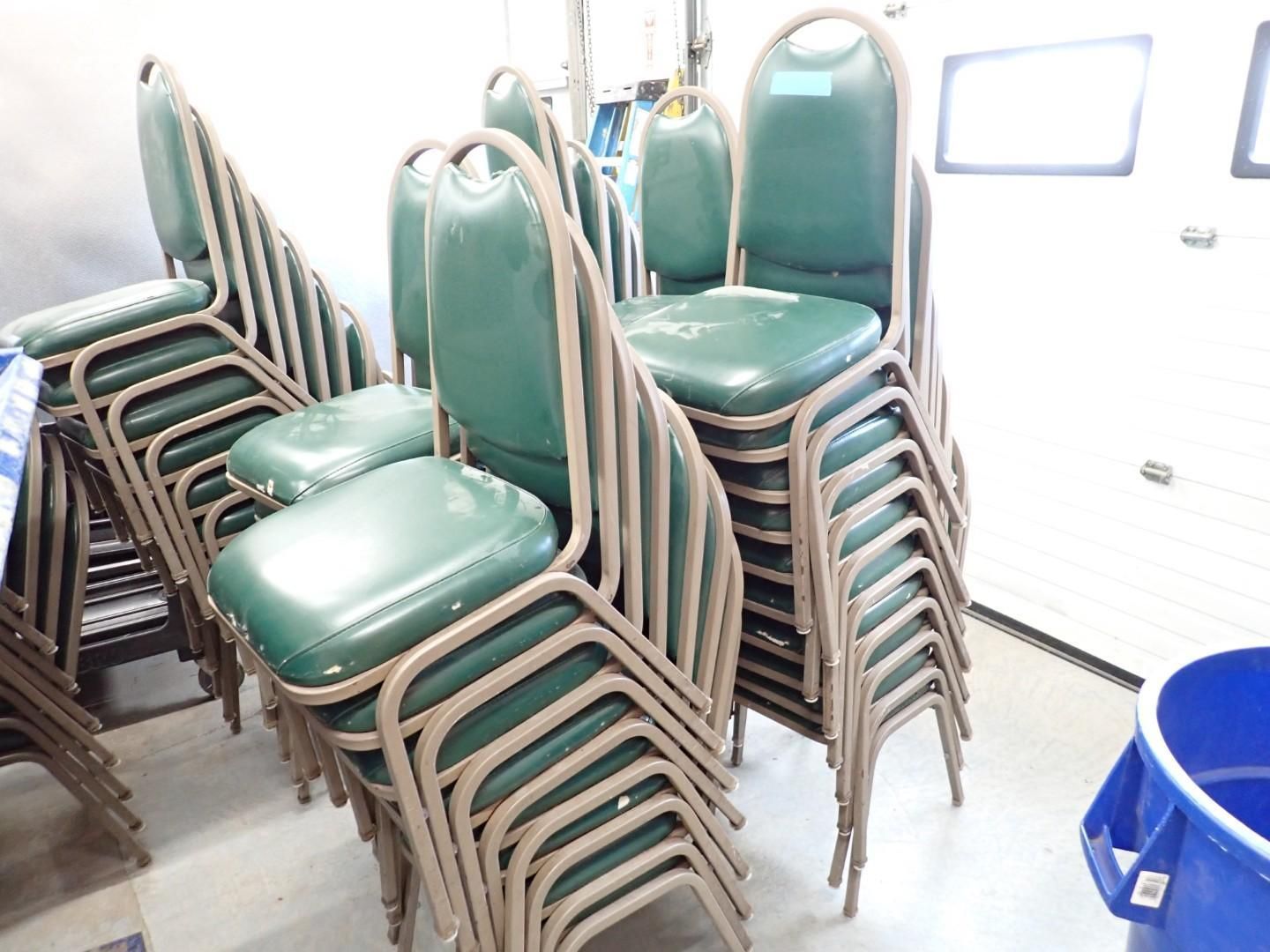 Stacked green-cushioned chairs in a storage room