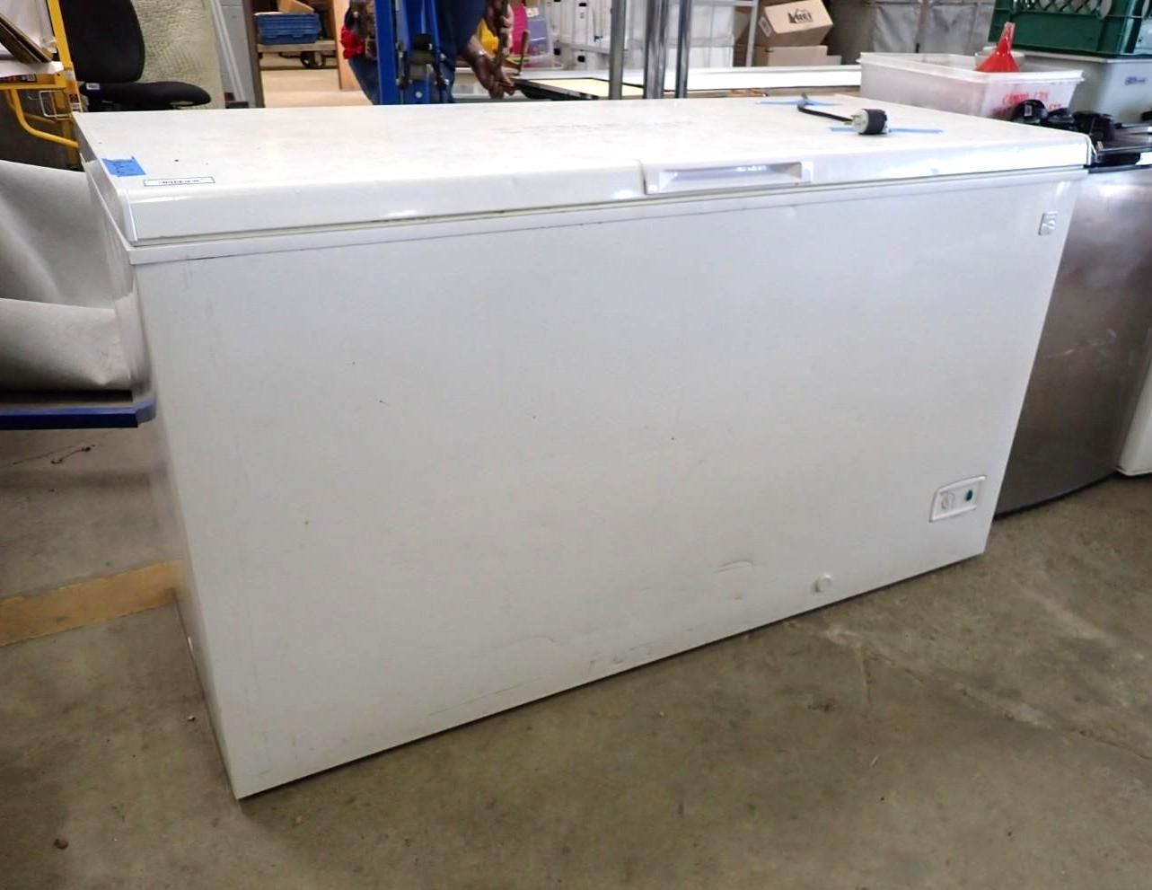 Large white chest freezer in a warehouse or garage setting