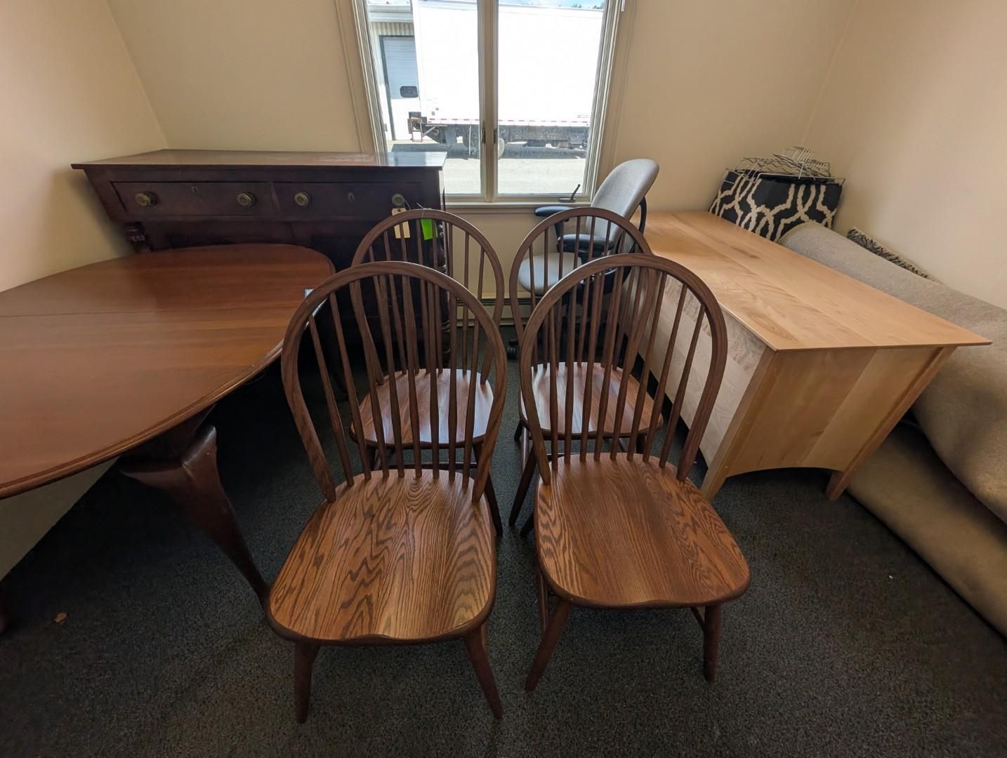Four wooden chairs, a desk, and a table