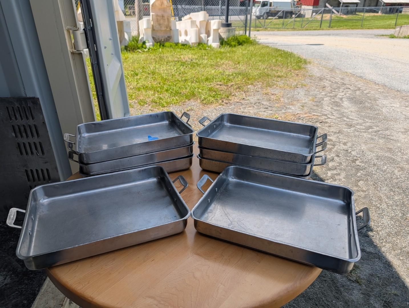 Four black baking trays stacked