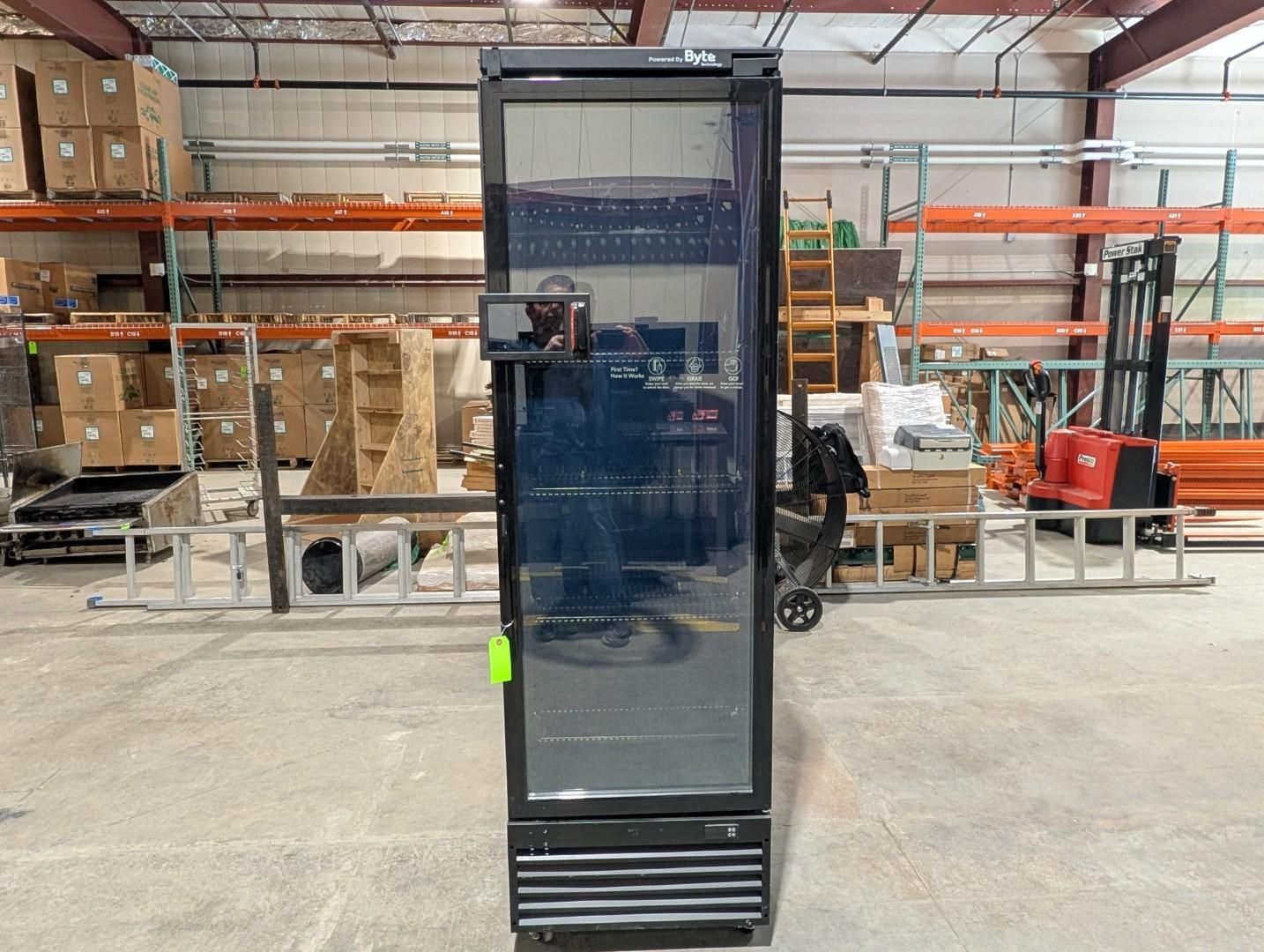 Tall black beverage cooler in a warehouse aisle