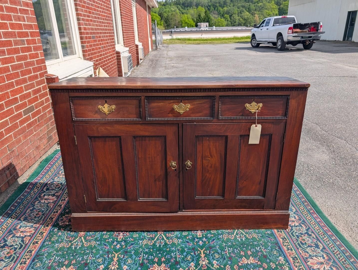 Dark wooden cabinet with ornate brass handles