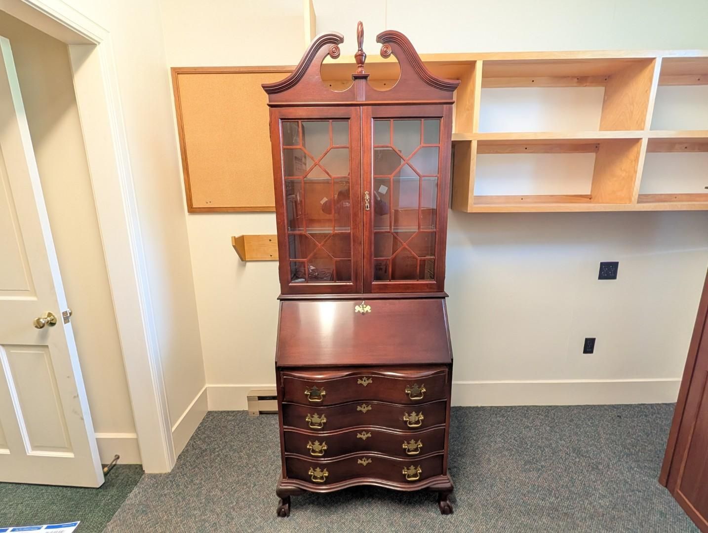 Tall dark wooden china cabinet with glass doors and drawers
