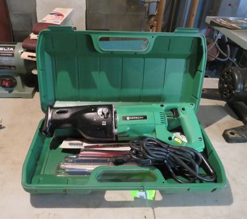 Green Hitachi reciprocating saw in its green case, with blades.