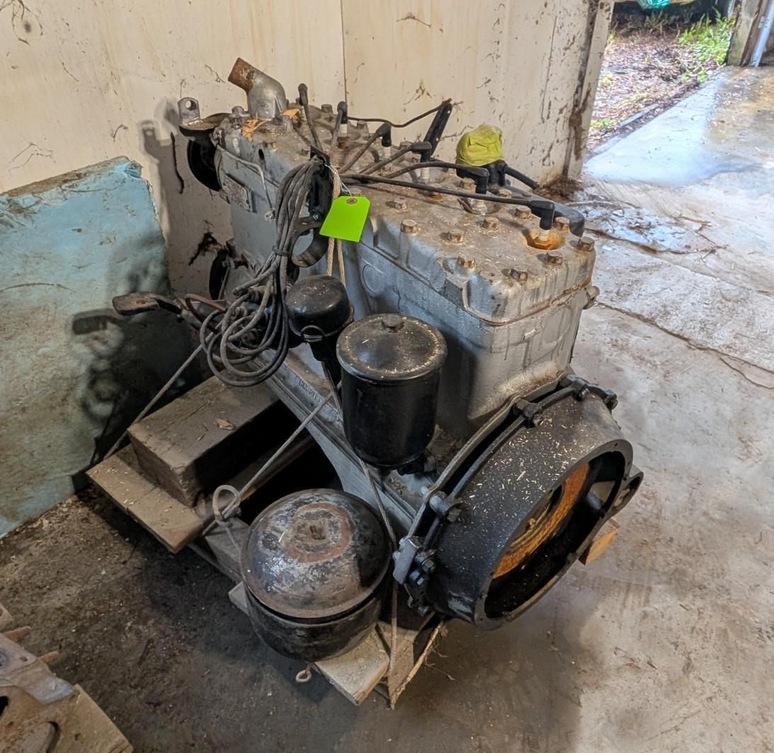 Old industrial engine on a concrete floor, with hoses and metal components