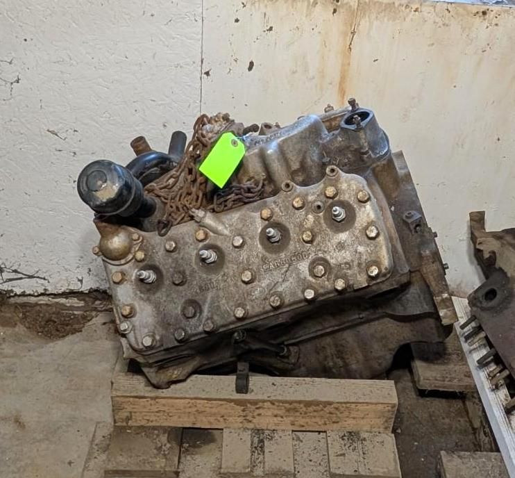 Used engine block on wooden pallet in a garage