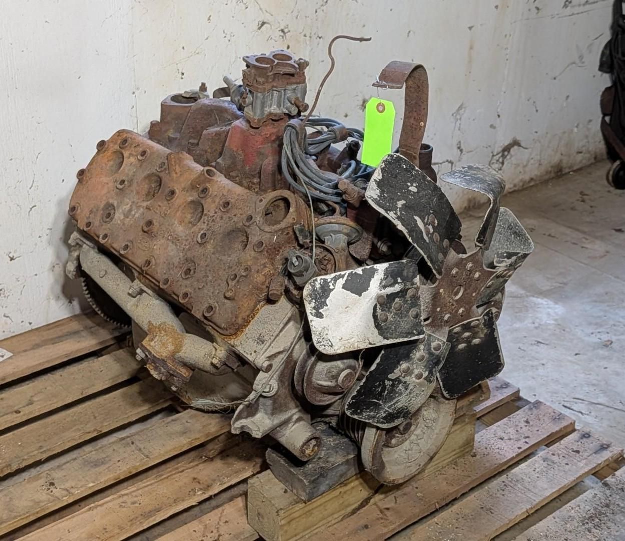 engine with a black fan on a wooden pallet in a workshop