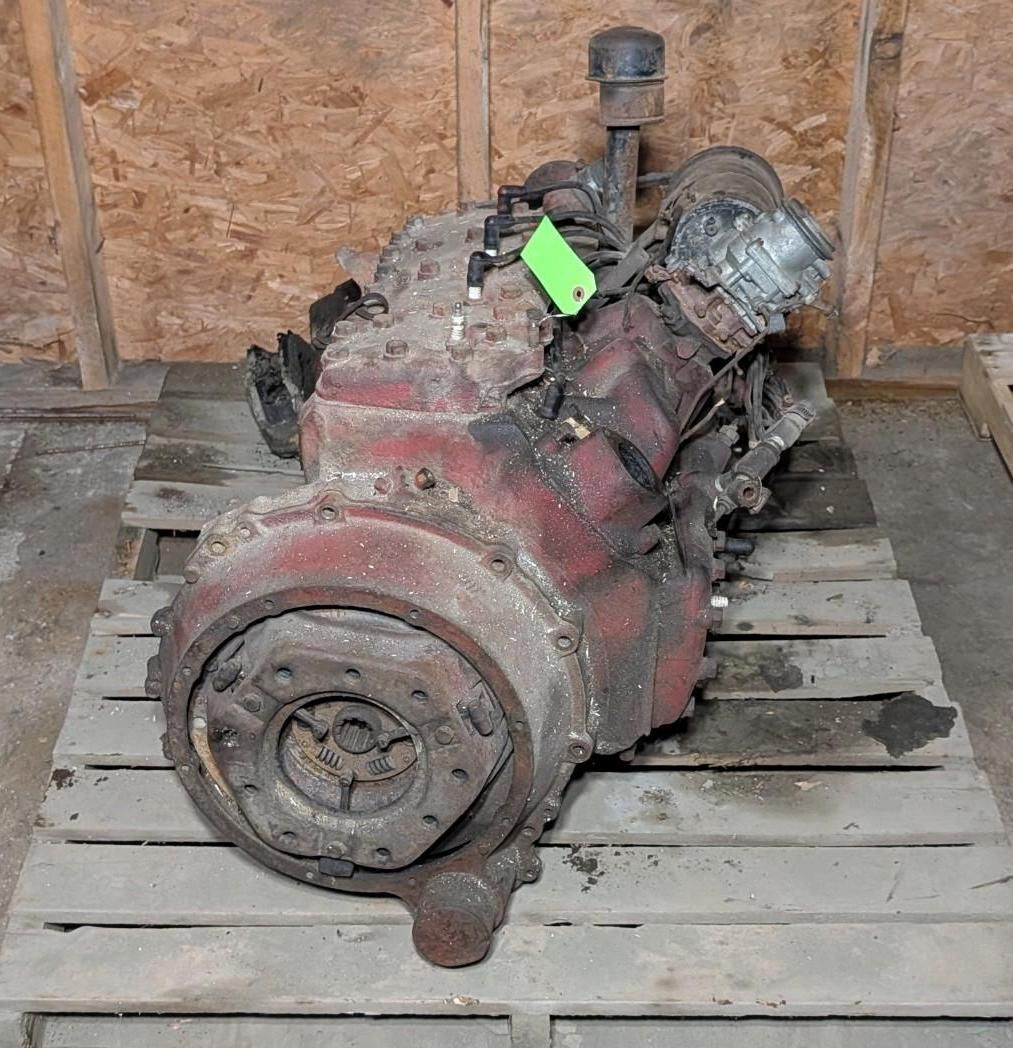 engine or transmission sitting on a wooden pallet in a workshop.