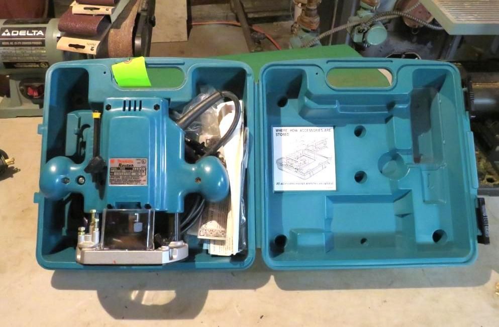 Blue Makita router in its open teal carrying case.