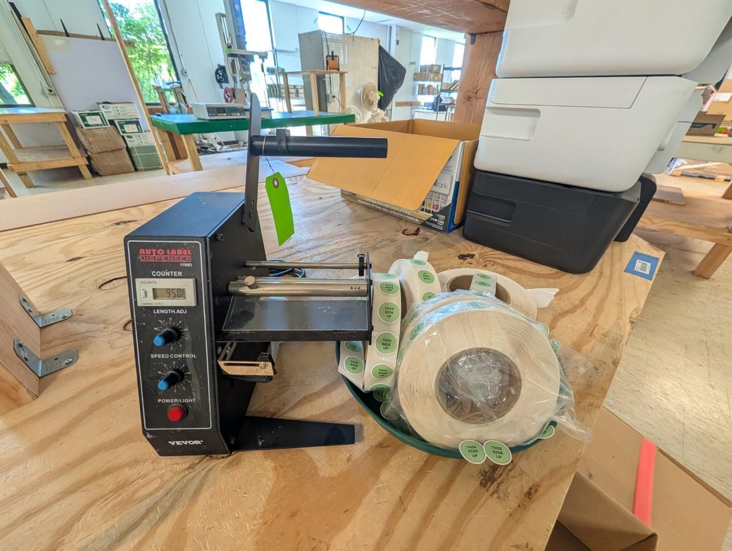 Industrial machine on a showroom floor, with a black control box and clear plastic-wrapped motor.