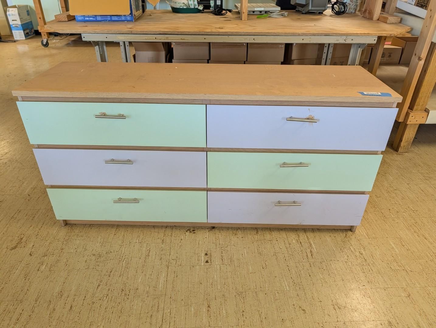 Pastel-painted low dresser with six drawers in a workshop
