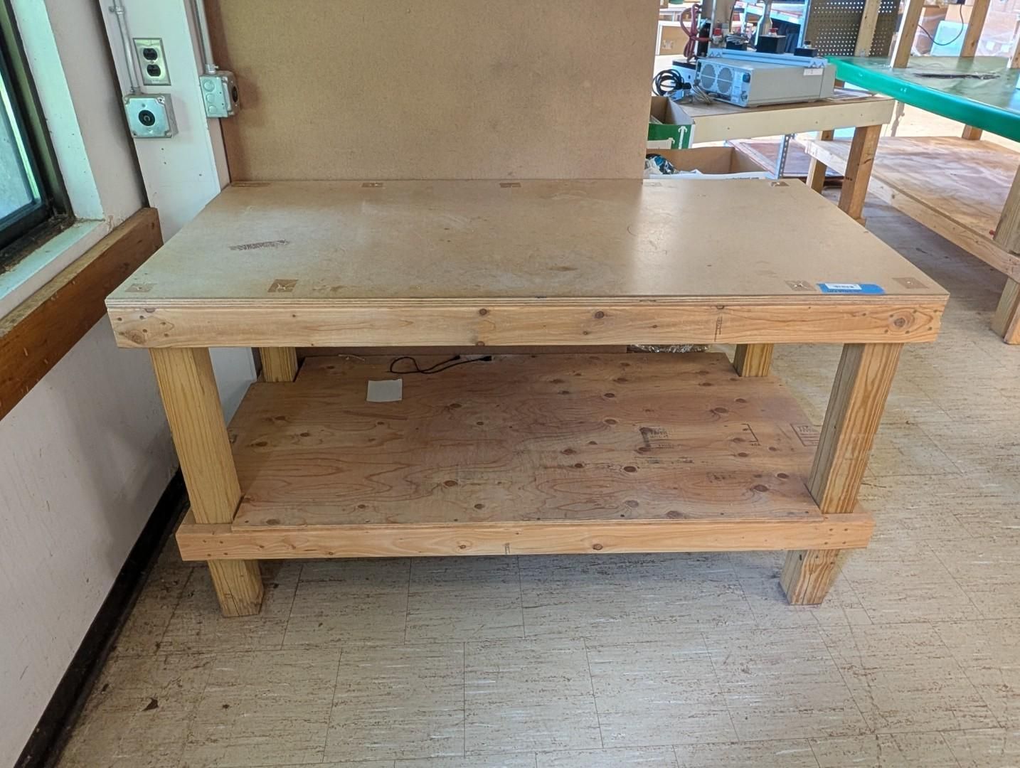 Wooden workbench on a tiled patio beside a window and outdoor deck.