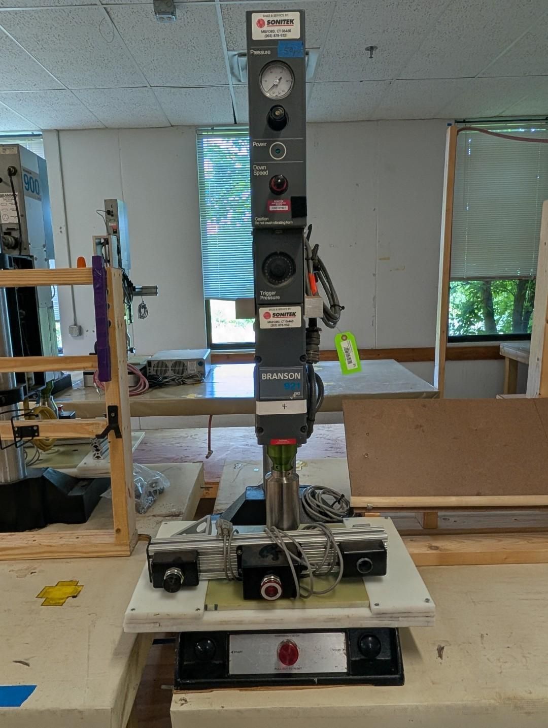 Vertical machine test rig on a workbench in a lab, with gauges, sensors, and a motor assembly.