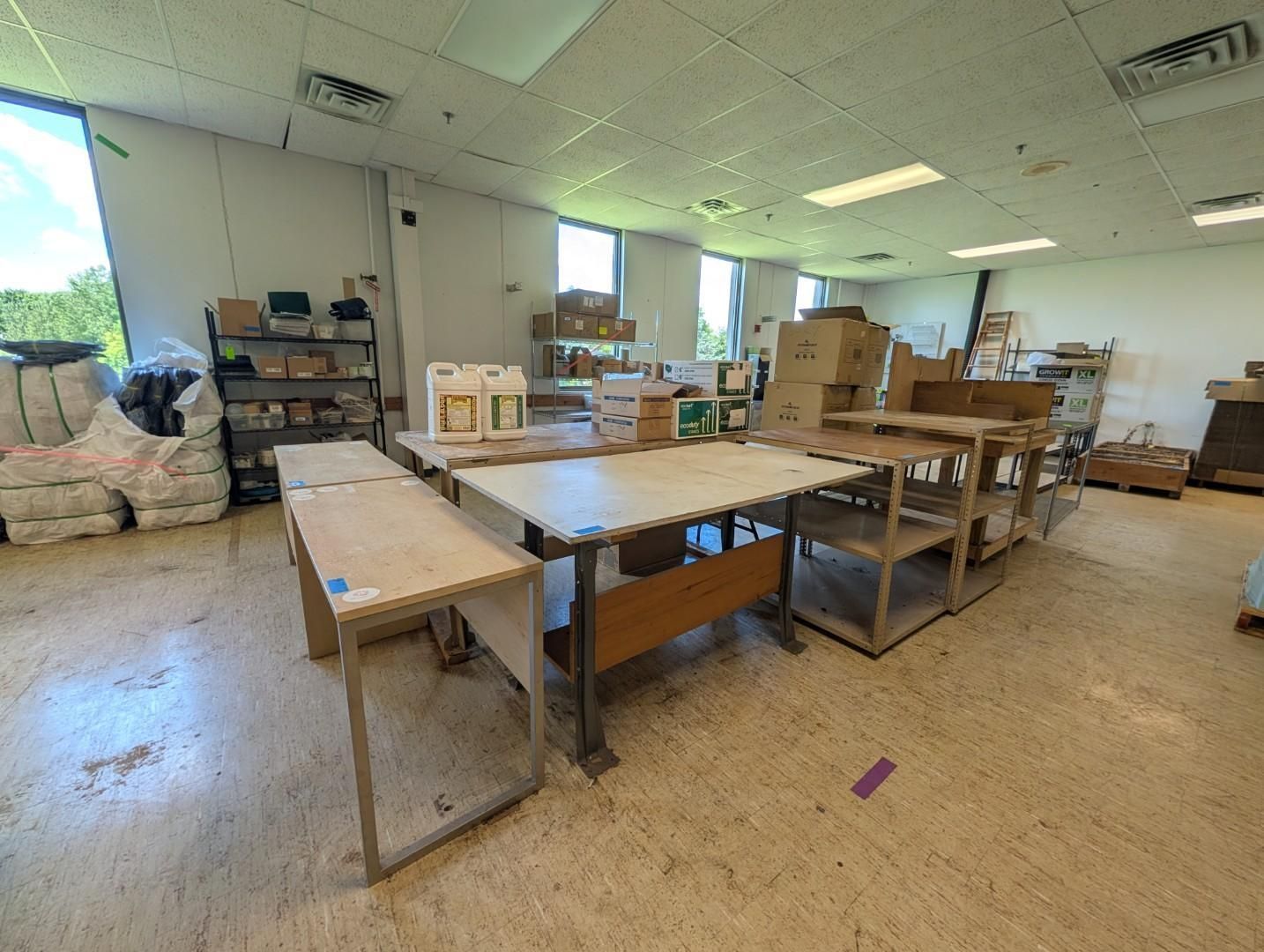 Bright workshop with tables, shelves, boxes, and a large open window