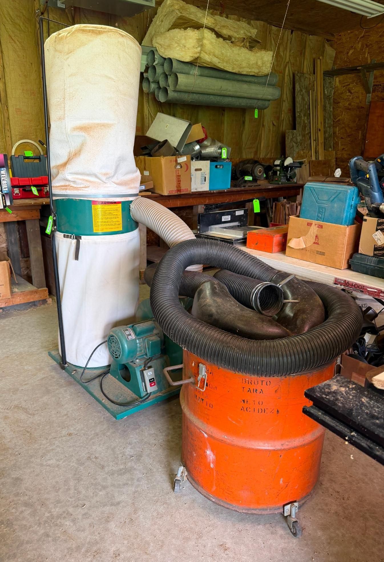 Workshop with orange shop vacuum, black hose, and duct collection bag