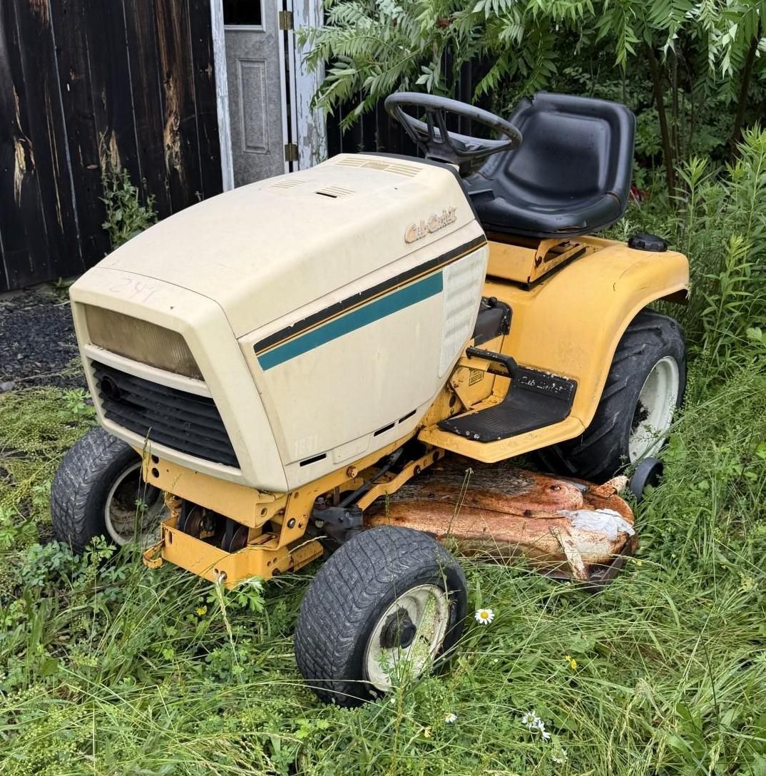 Beige and yellow riding lawn mower parked