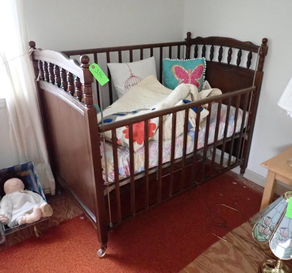 Wooden crib in a nursery corner with pillows, blankets