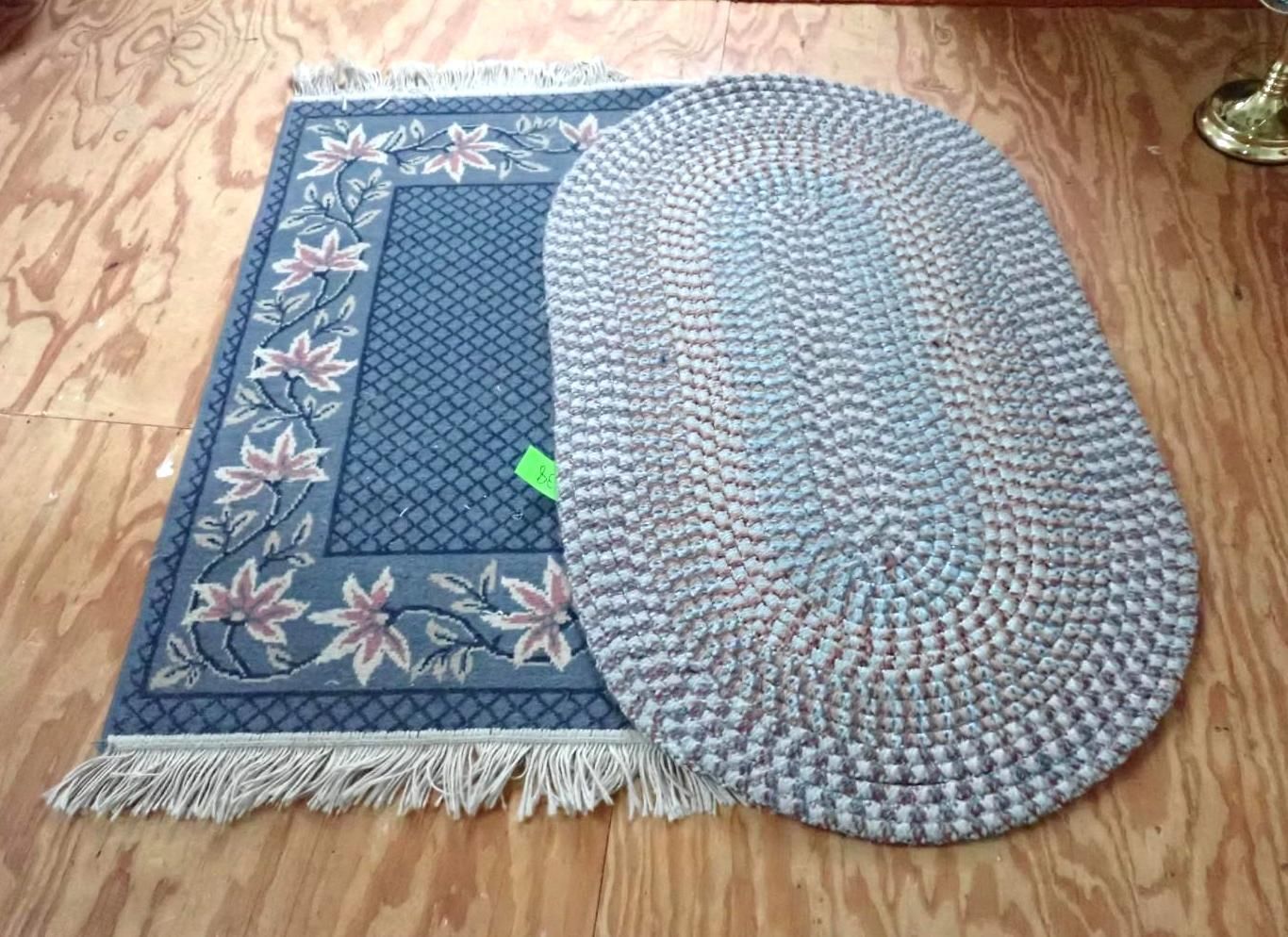 Two blue patterned floor mats on a wooden floor, one rectangular and one oval, partially overlapping.