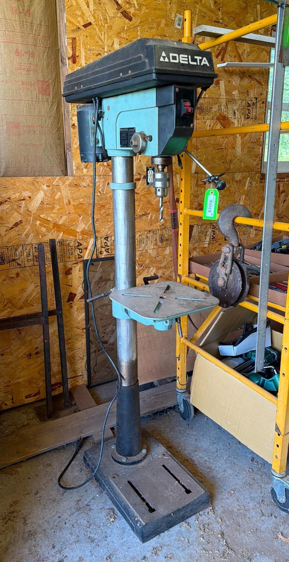 Blue drill press standing in a workshop