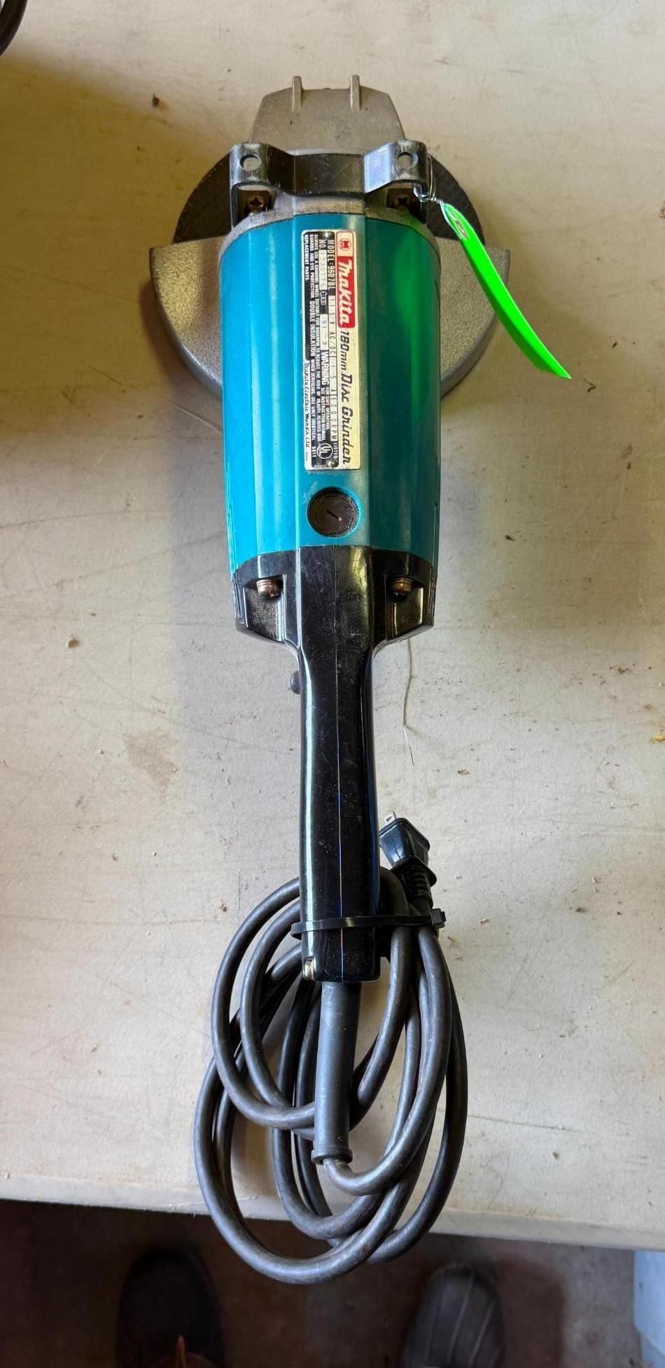 Blue handheld power tool with a coiled black cord