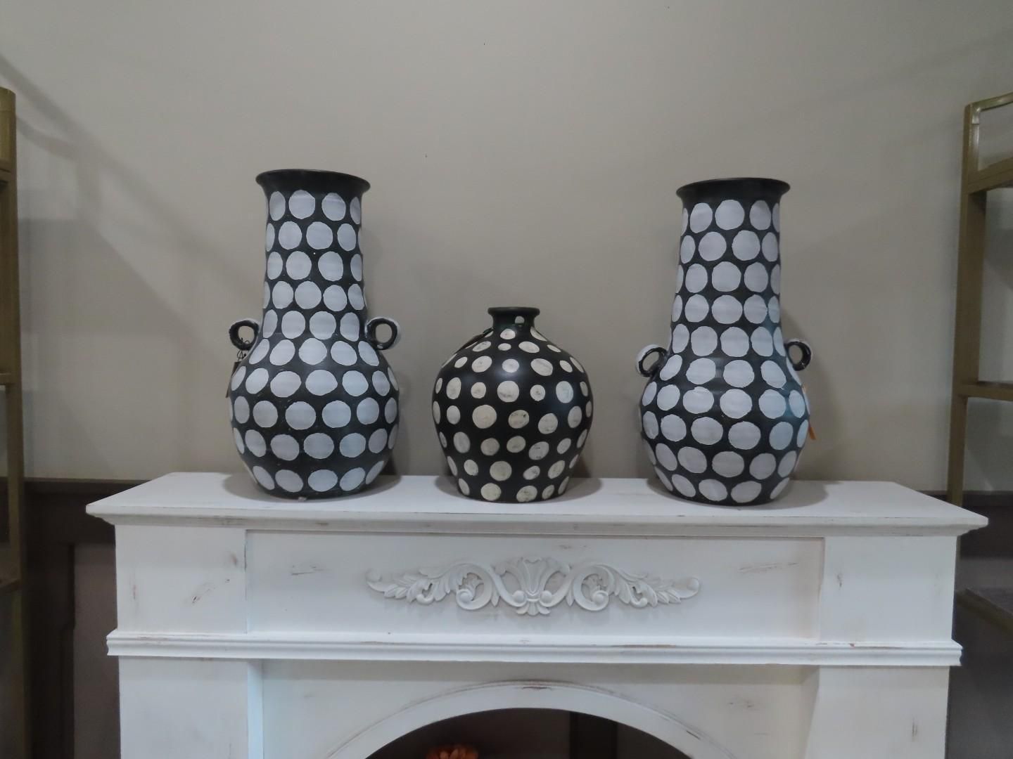 Three black-and-white patterned vases on a white mantel shelf