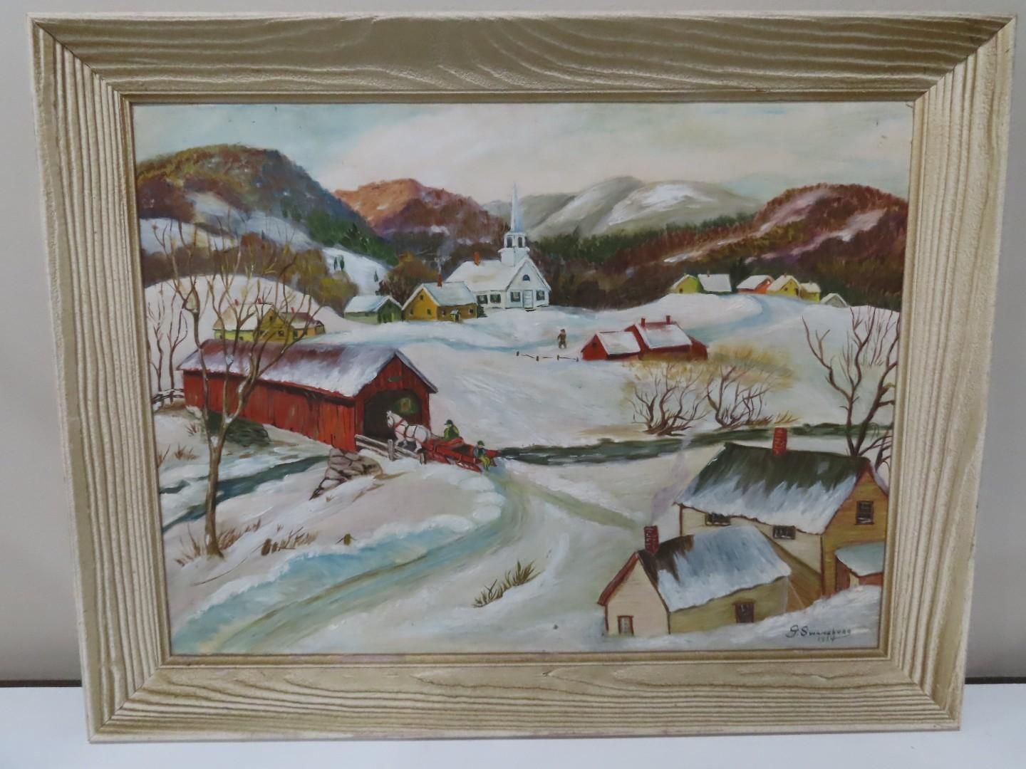 Snowy winter village landscape with barns, houses, and mountains in a framed painting