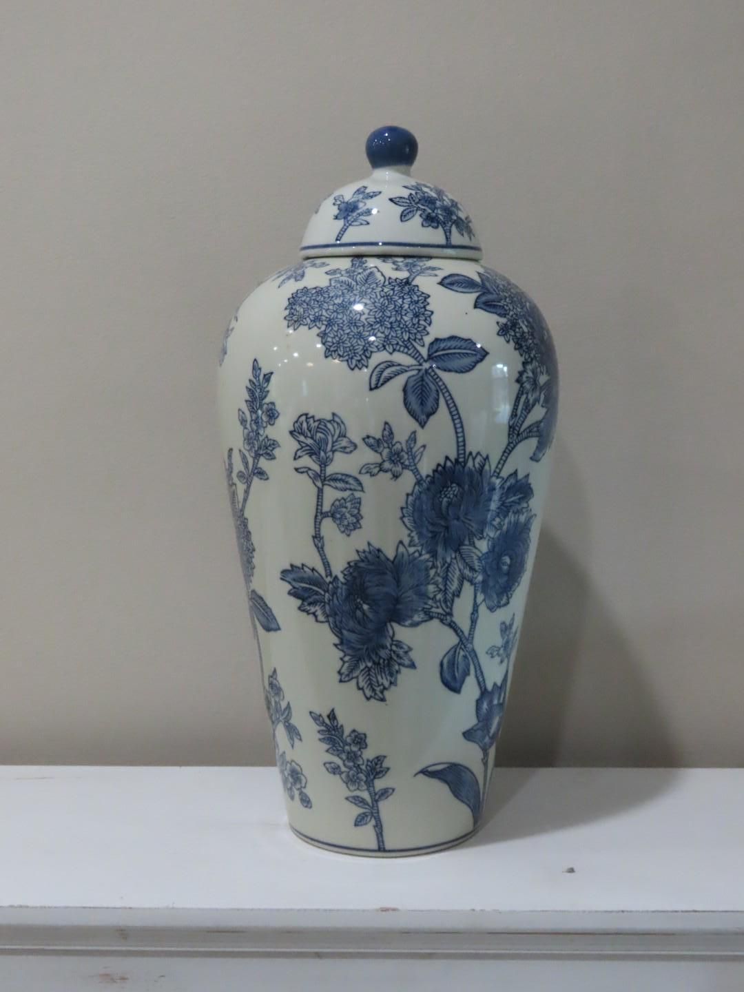 Blue-and-white floral porcelain vase on a white shelf against a gray wall