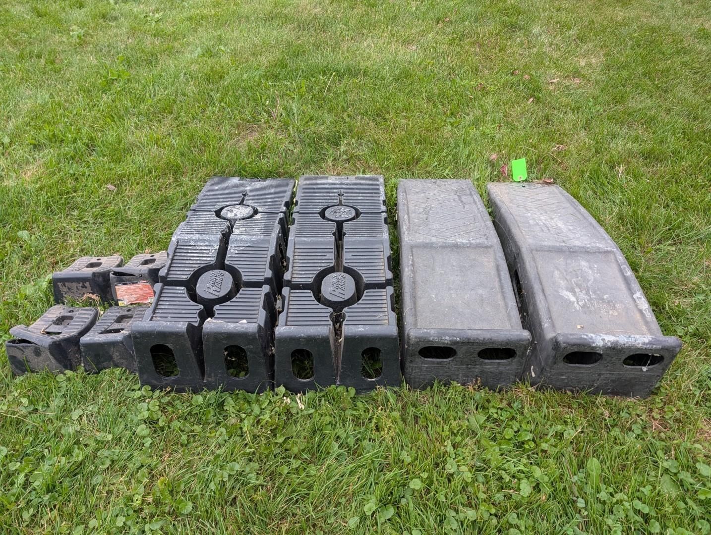 Stacked black and gray rubber blocks or bumpers laid on grass outdoors