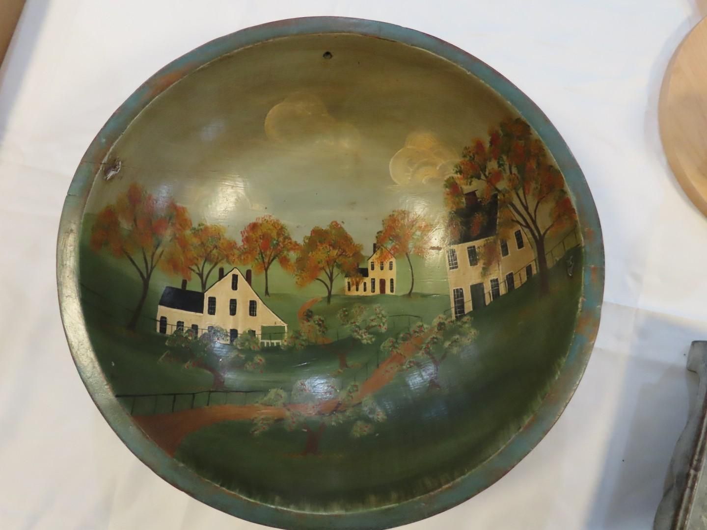 Round painted tray with a rural house scene in muted green, yellow, and brown tones