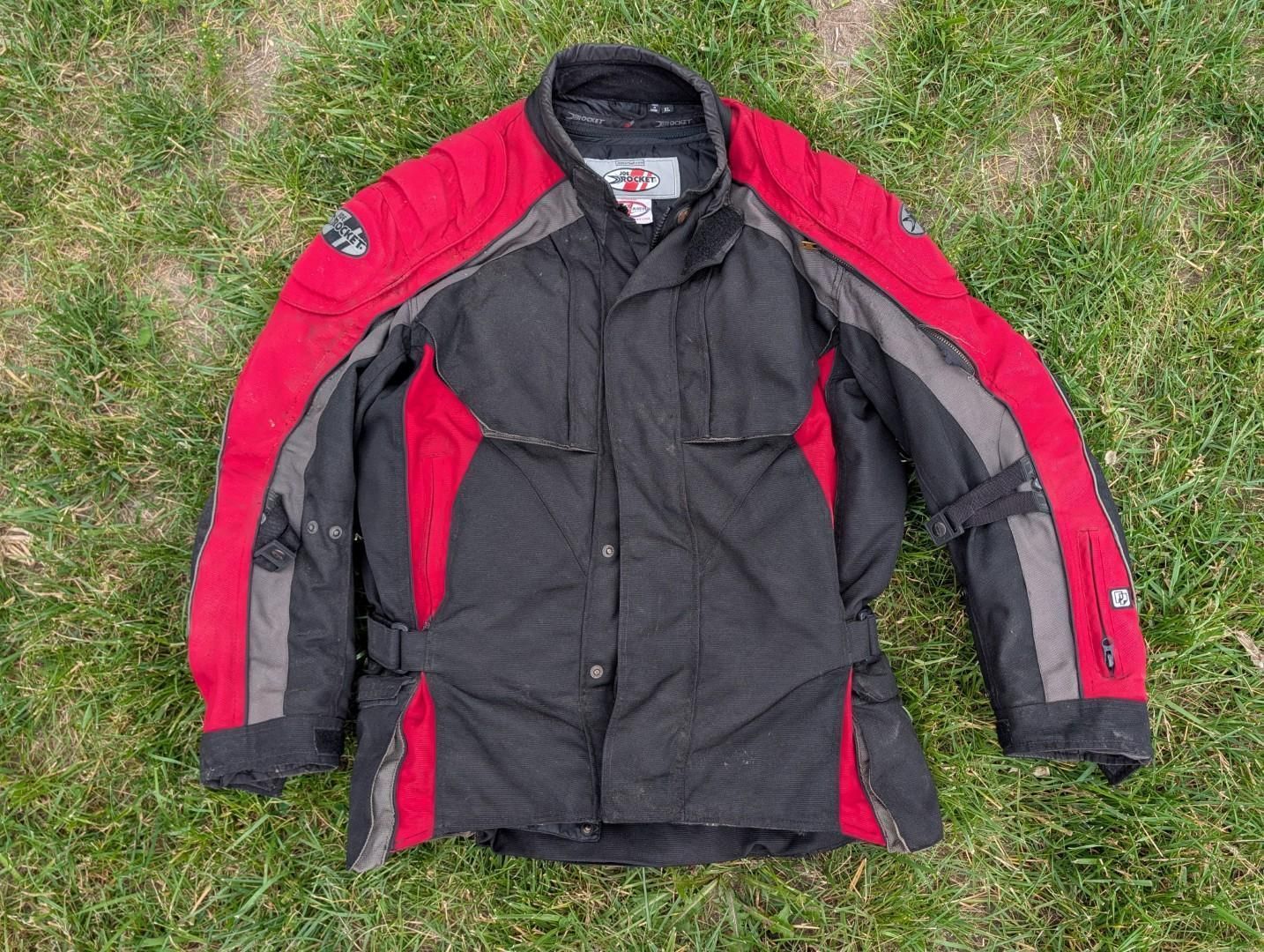 Black and red motorcycle jacket laid flat on grass
