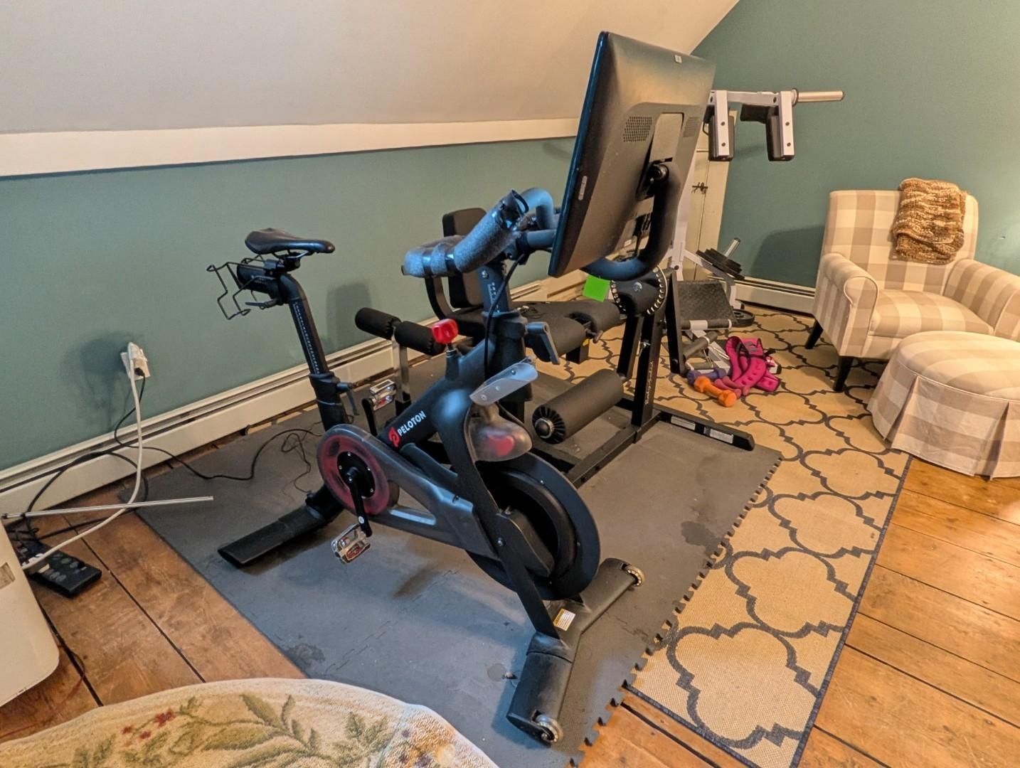 Home gym with an exercise bike, treadmill, weight bench