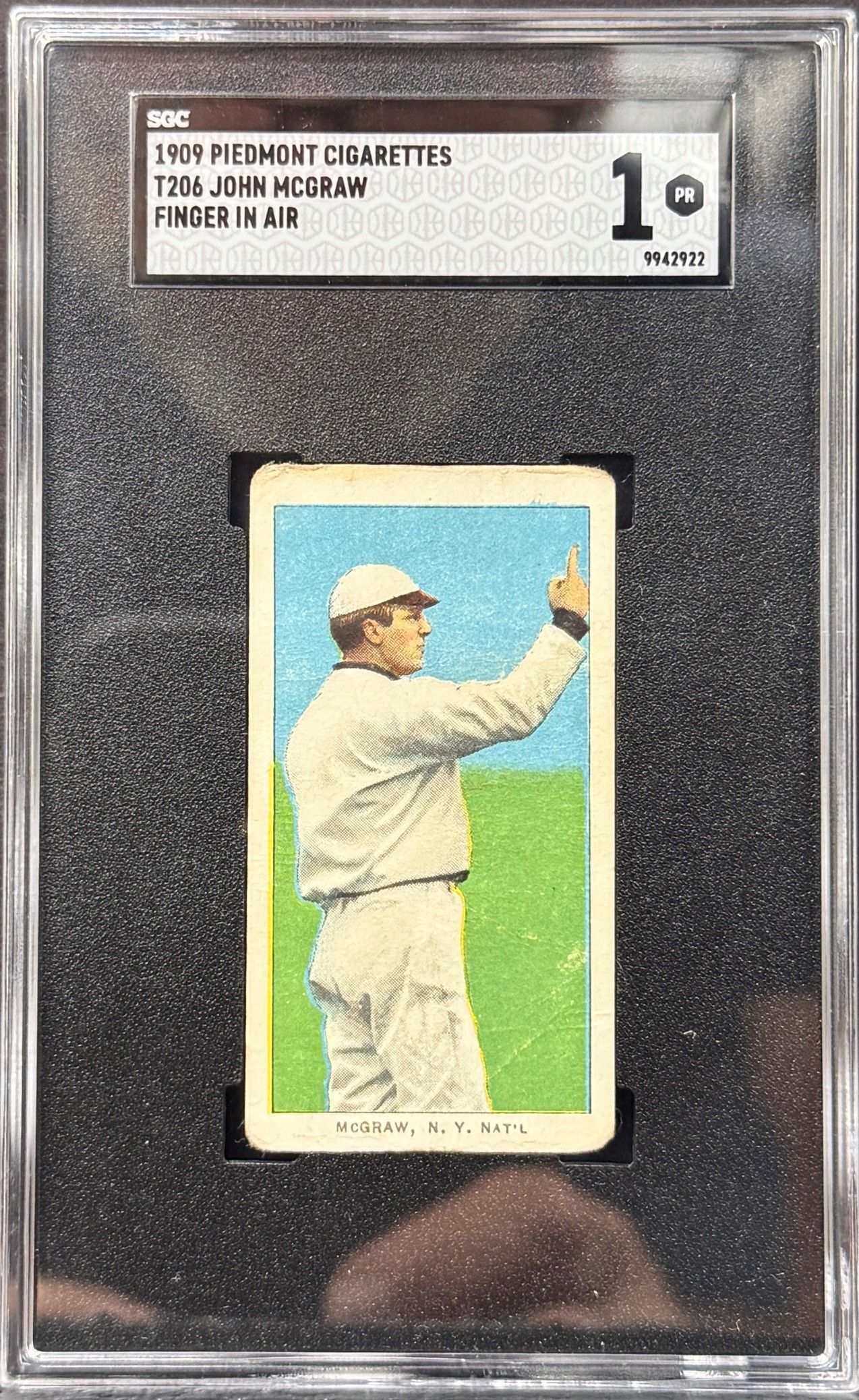 Framed vintage baseball card showing a player in white uniform raising a hand