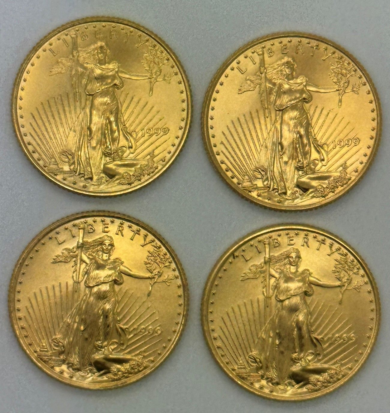 Four gold coins arranged in a 2x2 grid on a light gray background.