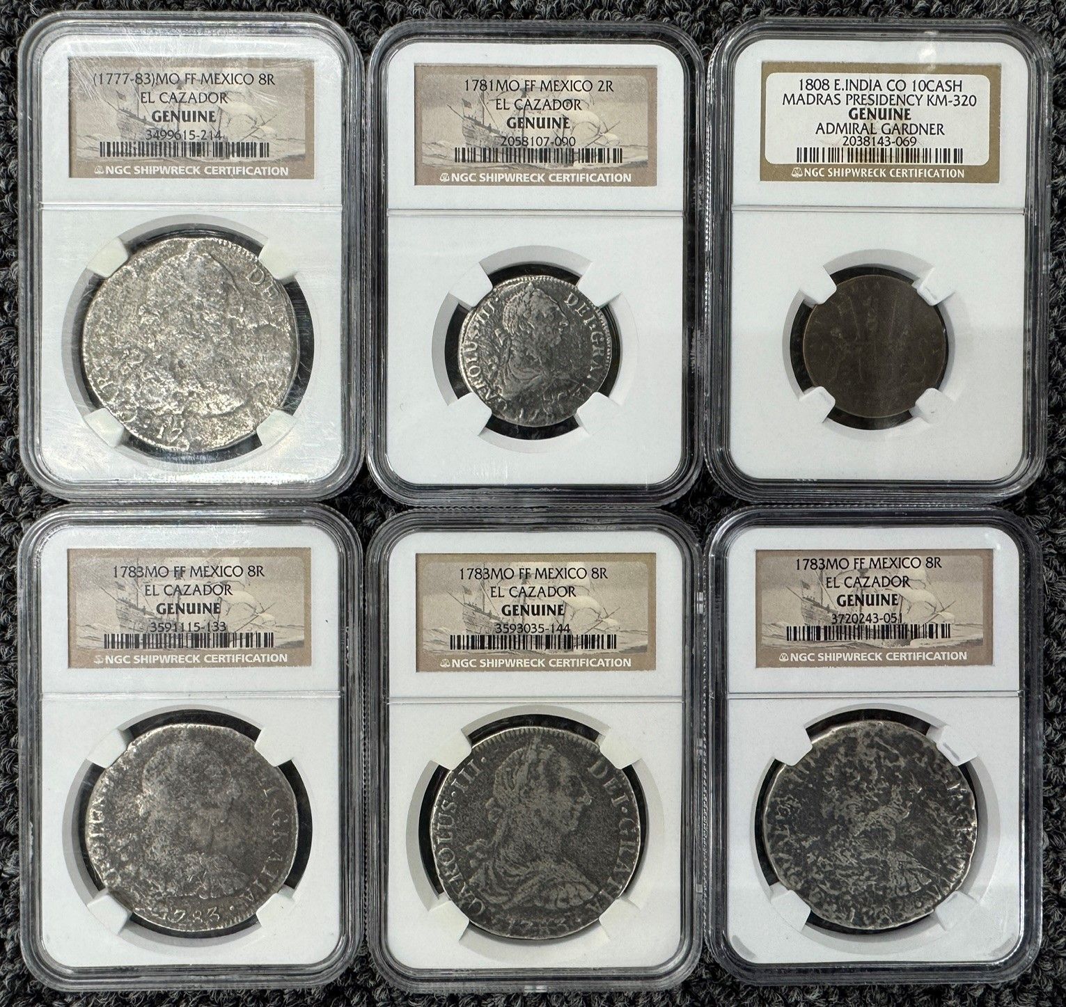 Six graded coin slabs arranged in two rows on a light surface.