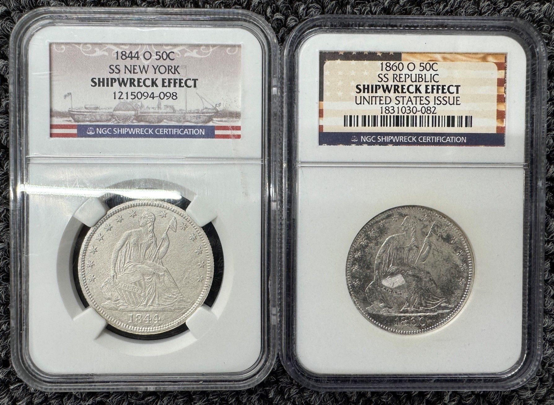 Two slabbed Shipwreck Effect coins in holders, one silver-toned and one darker with labels at top.