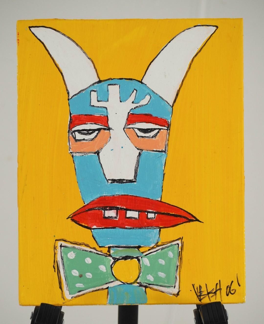 Cartoonish blue face with white horns on yellow background, red lips, green bowtie.