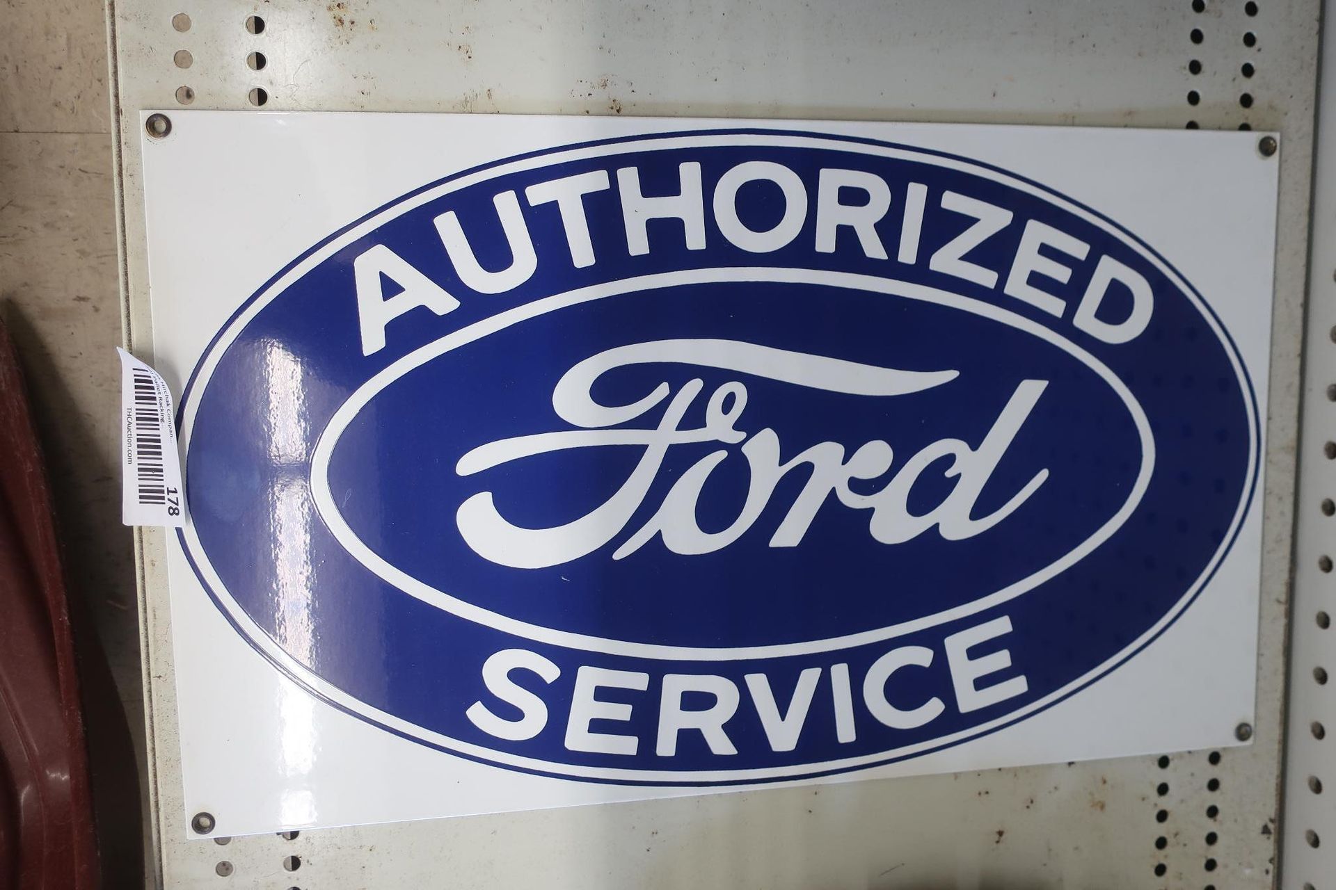 White sign with blue oval Ford logo and
