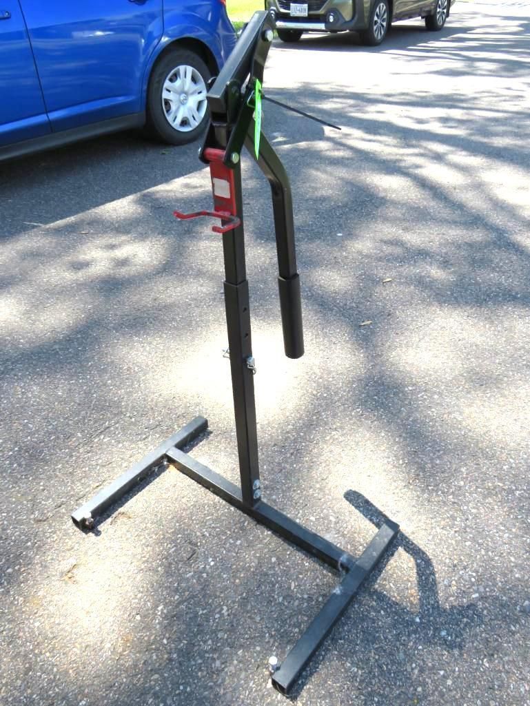 Black bicycle repair stand on asphalt.