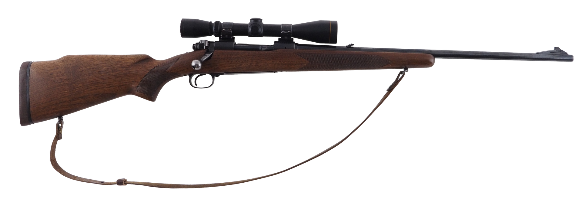 A hunting rifle with a scope, brown wood stock, and attached sling, resting against a white background.